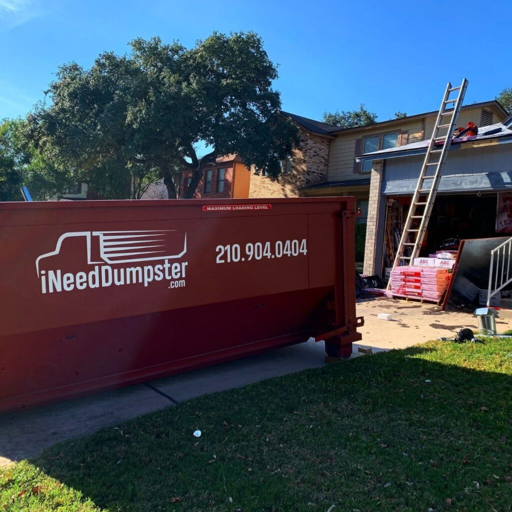 I Need Dumpster red dumpster sitting outside of a home in san antonio that's being renovated