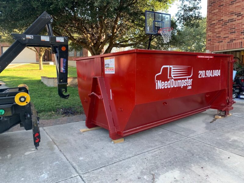 I Need Dumpster red dumpster sitting outside of a home in san antonio