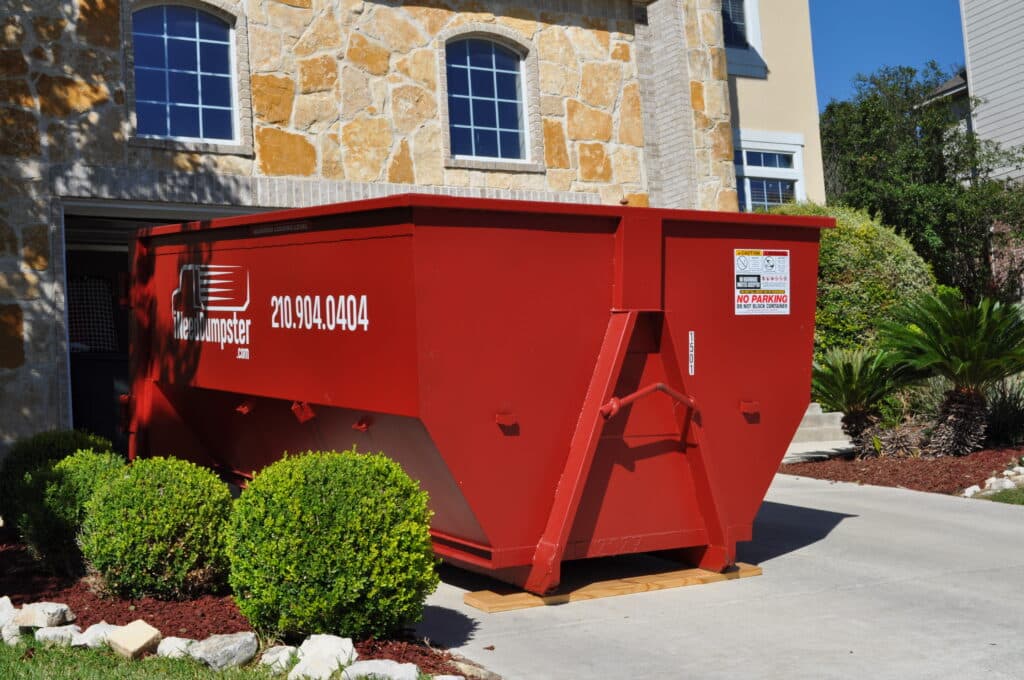I Need Dumpster red dumpster sitting outside of a home in san antonio