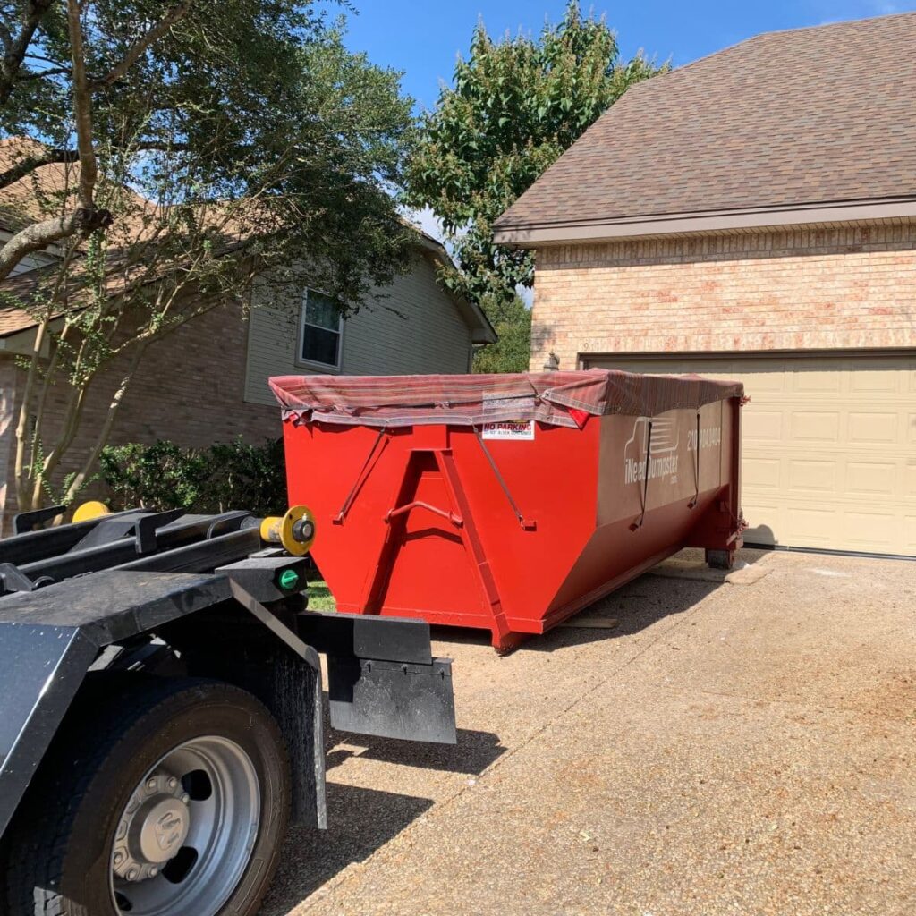 a covered I Need Dumpster red dumpster sitting outside of a home in san antonio