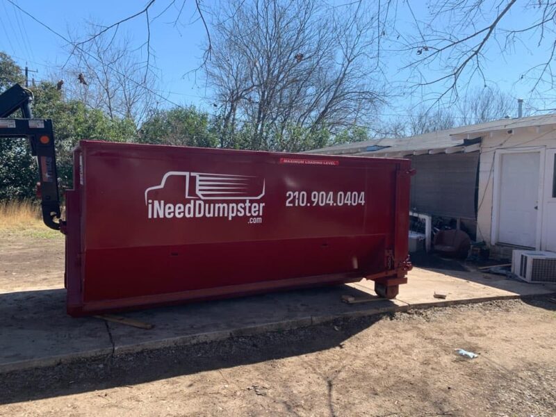 red dumpster from i need dumpster sitting outside of home ready to be used for trash removal